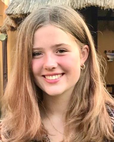 Portrait of person with shoulder length mousey brown hair smiling at the camera